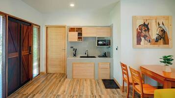 A compact kitchen with wooden cabinets, a sink, and a dining area with chairs and a table.