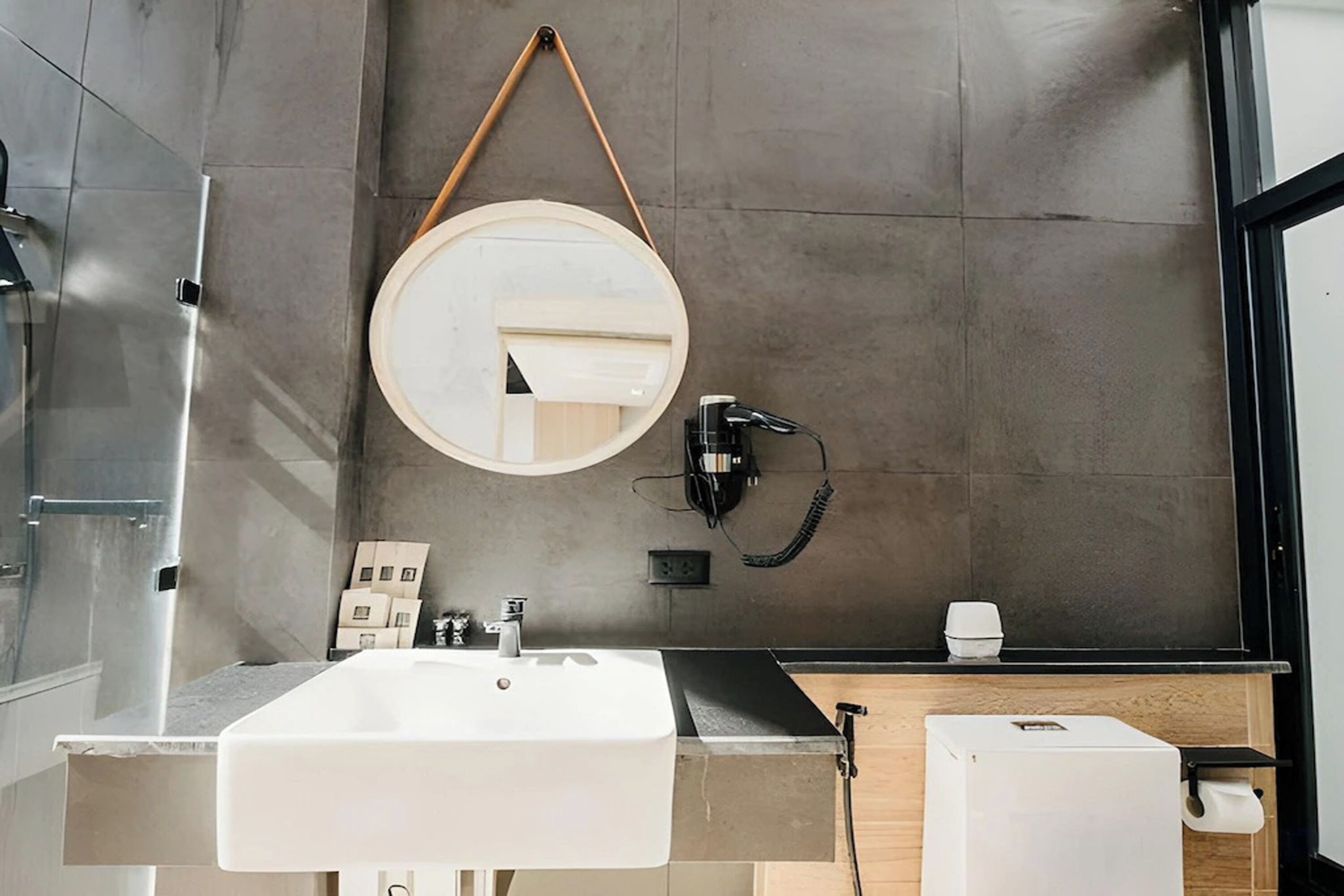 Une salle de bain moderne avec un grand miroir, un lavabo et des toilettes.