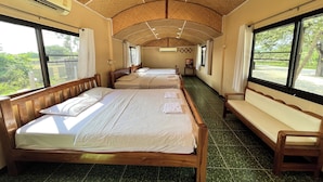 A room with two wooden beds, a bench, and large windows. - Rabiangmai Resort (Kanchanaburi)