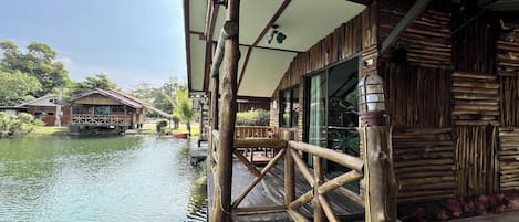 Eine Holzkonstruktion mit einem über dem Wasser liegenden Deck, inklusive Geländer und einem überdachten Bereich mit Decke.