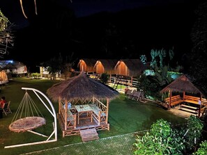 A thatched-roof structure with a wooden deck and a swing. - Lion Cafe Resort (Hang Dong)