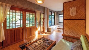 A traditional Japanese-style room with tatami flooring, sliding doors, and a low wooden table. - Lion Cafe Resort (Hang Dong)