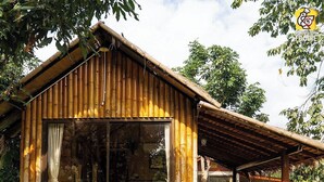A wooden cabin with a large glass window, a wooden deck, and a covered outdoor seating area. - Lion Cafe Resort (Hang Dong)