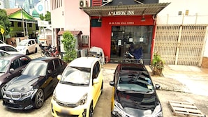 Un parking où plusieurs voitures sont garées devant un bâtiment portant l’inscription « AP AMSON INN ».