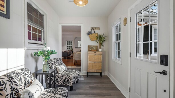 A hallway with patterned sofas, a wicker basket, and a wooden cabinet. - Cozy 4-BR Getaway :Private yard, Gazebo & Grill,  (Fairfax)