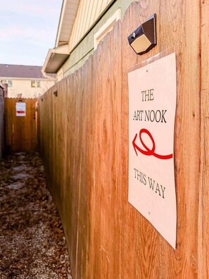 A wooden fence with a sign that reads "THE ART NOOK THIS WAY" and a red arrow pointing to the right. - The Art Nook | 5 Mins to Airport| Peaceful Retreat (Boise)