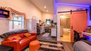 Ett kompakt bostadsutrymme med ett litet kök, en matplats och ett sovrum.