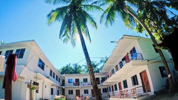 A two-story building with a central courtyard, surrounded by palm trees. - Sea Probal Beach Resort Saint Martin (Saint Martin's Island)