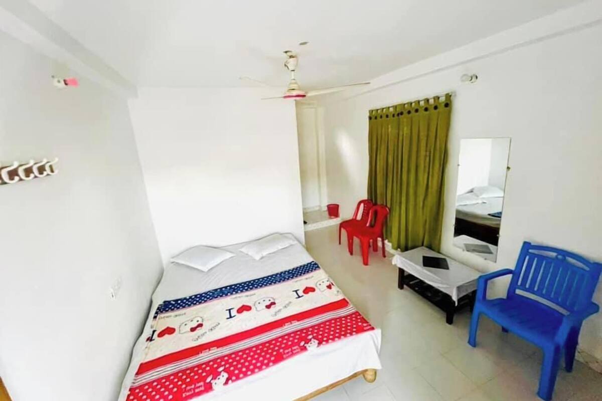 Una habitación pequeña y limpia con cama, escritorio, silla y espejo.