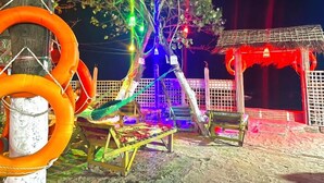 A hammock under colorful lights, a small wooden structure, and a red canopy. - Sea Probal Beach Resort Saint Martin (Saint Martin's Island)