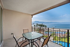 Outdoor dining - Oceanfront Grand Venetian Condo • Private Balcony • Pools • Gym • Beach Access (Puerto Vallarta)