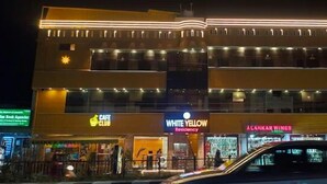 A multi-story building with a cafe, a residency, and a wine shop. - White Yellow Residency (Puducherry)