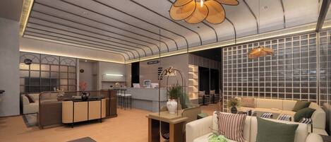 A modern living area with a sofa, a coffee table, and a kitchen area in the background.