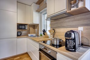 A modern kitchen with white cabinetry, a microwave, a coffee maker, and wooden countertops. - Villa Ancora - Merope Apt /w Jacuzzi & Terrace, Nerezine, Croatia (Nerezine)