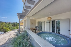 A balcony with a hot tub, outdoor seating, and a view of the surrounding landscape. - Villa Ancora - Merope Apt /w Jacuzzi & Terrace, Nerezine, Croatia (Nerezine)