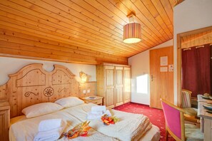 A wooden-paneled room with a bed, a nightstand, a chair, and a door. - Hotel Relais Alpin Single Ski In-Out 3 133, Les Mosses, Switzerland (Les Mosses)
