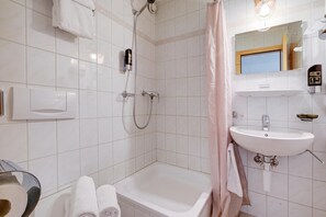 Ett modernt badrum med badkar, dusch och handfat.
