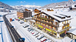 A hotel with a ski lift, snow-covered surroundings, and a road with parked cars. - Hotel Relais Alpin Family Room & Balcony5 136, Les Mosses, Switzerland (Les Mosses)