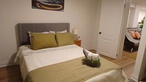 Une chambre à coucher avec un lit, une table de chevet, une lampe et un tableau au mur.