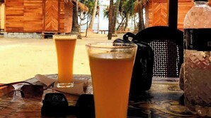 A tropical setting with wooden huts and palm trees. - Aroma Beach Resort Saintmartin (Saint Martin's Island)