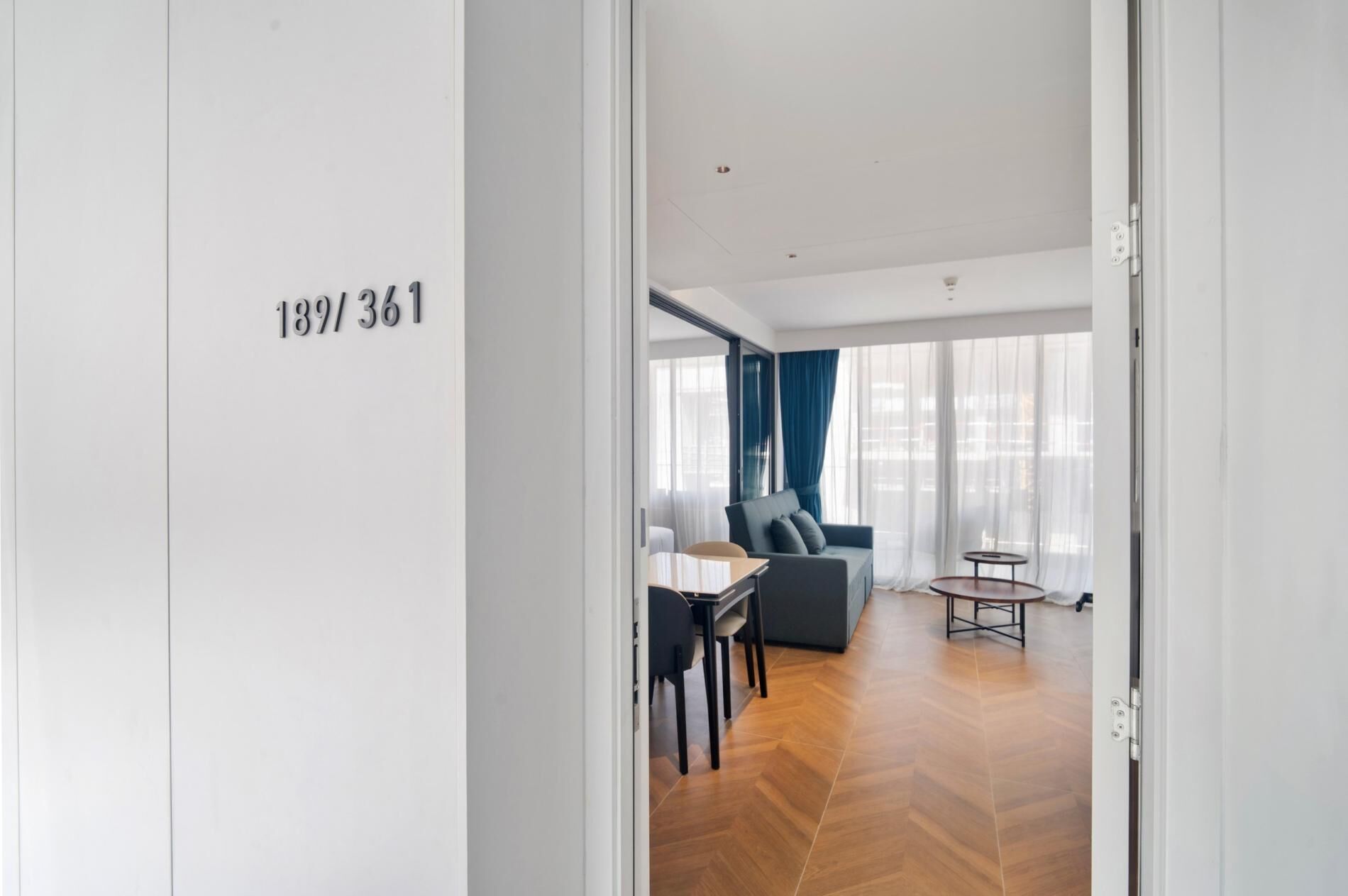 Une chambre d’hôtel moderne avec un plancher en bois, un canapé, une petite table et une chaise.