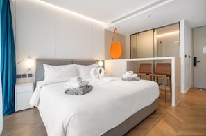Ein modernes Hotelzimmer mit einem großen Bett, einem Schreibtisch und einer Sitzecke.
