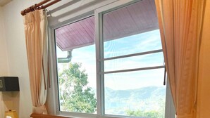 A neatly made bed with white linens, a wooden headboard, and a window with curtains. - Sunset Ocean View 3-king bed Villa Directly Above Patong (Phuket)