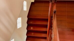 A wooden staircase with a handrail and patterned wall decorations. - Sunset Ocean View 3-king bed Villa Directly Above Patong (Phuket)