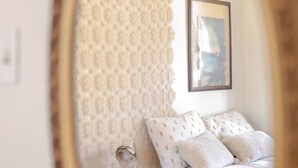 A bedroom with a bed, a nightstand, a lamp, and a framed picture on the wall. - Stylish Musician`s Flat With Creekside Garden (Austin)