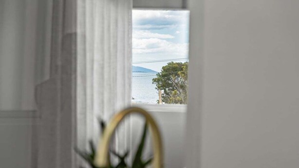 Una habitación con vista al agua y una montaña distante.