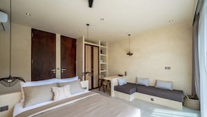Un dormitorio moderno con una cama grande, un escritorio y un área de descanso.