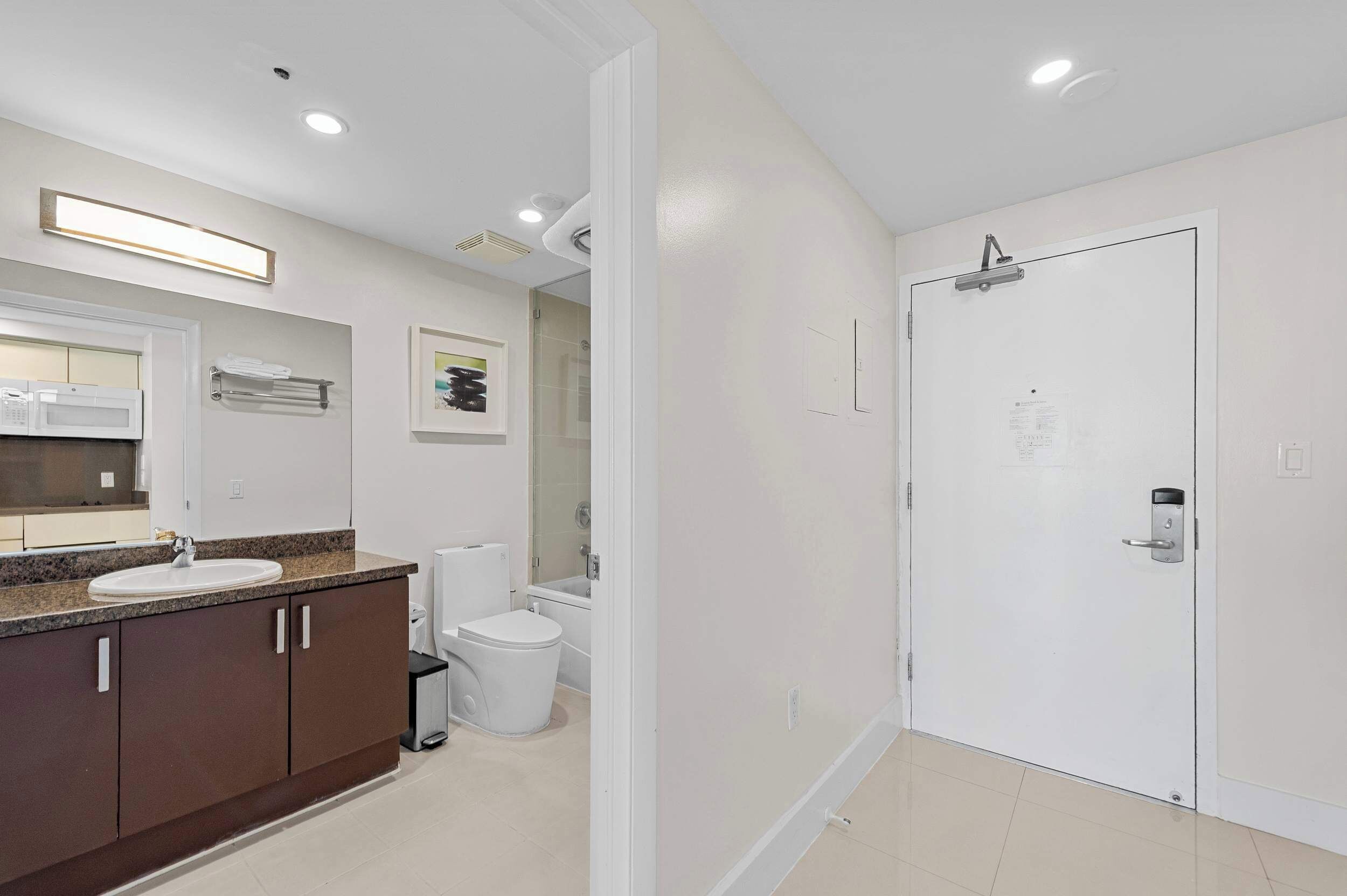 Un baño moderno con lavamanos, inodoro y zona de ducha.