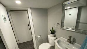 Ein Badezimmer mit Toilette, Waschbecken und Spiegel.