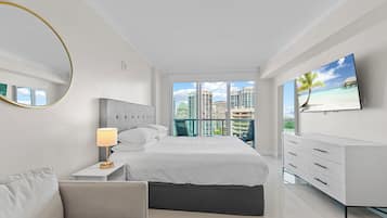 Ein modernes Hotelzimmer mit einem großen Bett, einem Nachttisch mit Lampe, einem an der Wand montierten Fernseher und Blick auf die Stadt durch große Fenster.