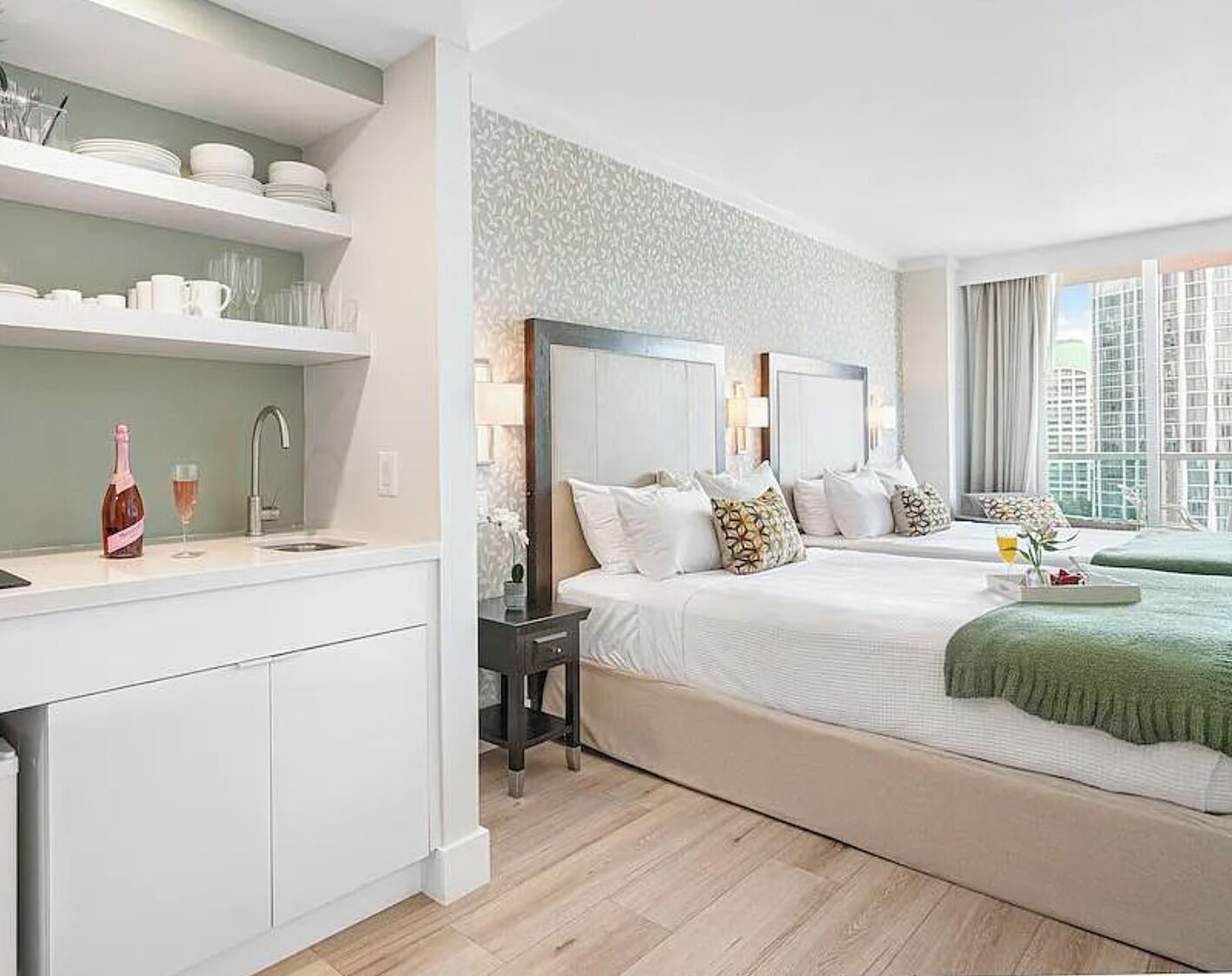 Una habitación de hotel moderna con una cama grande, un escritorio pequeño y vistas a la ciudad.