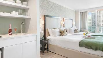 Una habitación de hotel moderna con una cama grande, un escritorio pequeño y vistas a la ciudad.