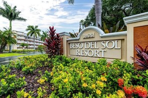 A sign for 'Beso Del Sol Resort' with a number '1420' and a landscaped area with various plants and flowers. - Studio King Sunset at Beso Del Sol with Pool & Hot Tub (Dunedin)