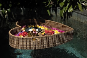 A wicker basket with flowers and candles on water. - Villa Naka - Gili Trawangan - Traditional Villa & Private Pool (Gili Trawangan)