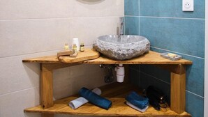 A bathroom with a round mirror, a stone sink, wooden shelves, and a blue-tiled wall. - Loft Mini-Toy - Playful & Romantic Love Room (CARSPACH)