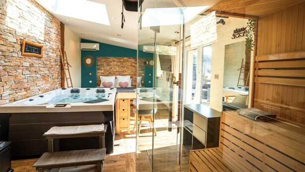 A modern spa room with a hot tub, wooden benches, and a glass partition. - Loft Mini-Toy - Playful & Romantic Love Room (CARSPACH)