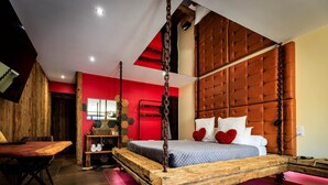 A bedroom with a wooden bed frame, a red accent wall, and a tufted headboard. - Loft Olé-Olé - Erotic Love Room & Barrel Sauna (CARSPACH)