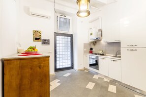 Eine moderne Küche mit weißen Schränken, einer Holz Arbeitsplatte, einem eingebauten Backofen und einer Spüle aus Edelstahl.