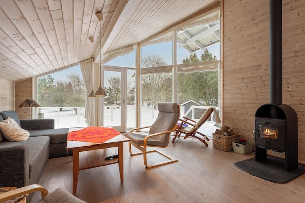 A cozy room with a sofa, a chair, a table, and a fireplace.