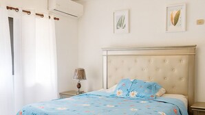 Una camera da letto con un letto, un comodino, una lampada e un lampadario.