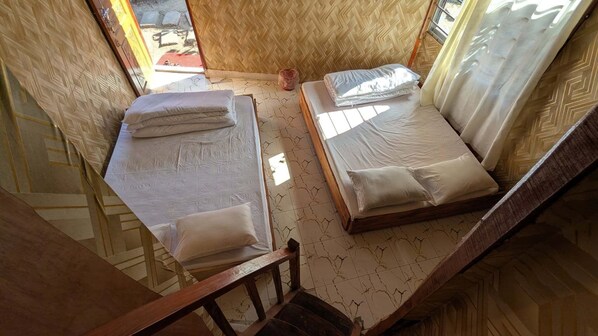 A room with two beds, a wooden floor, and a window. - Beach Valley Eco Resort Saint Martin (Saint Martin's Island)