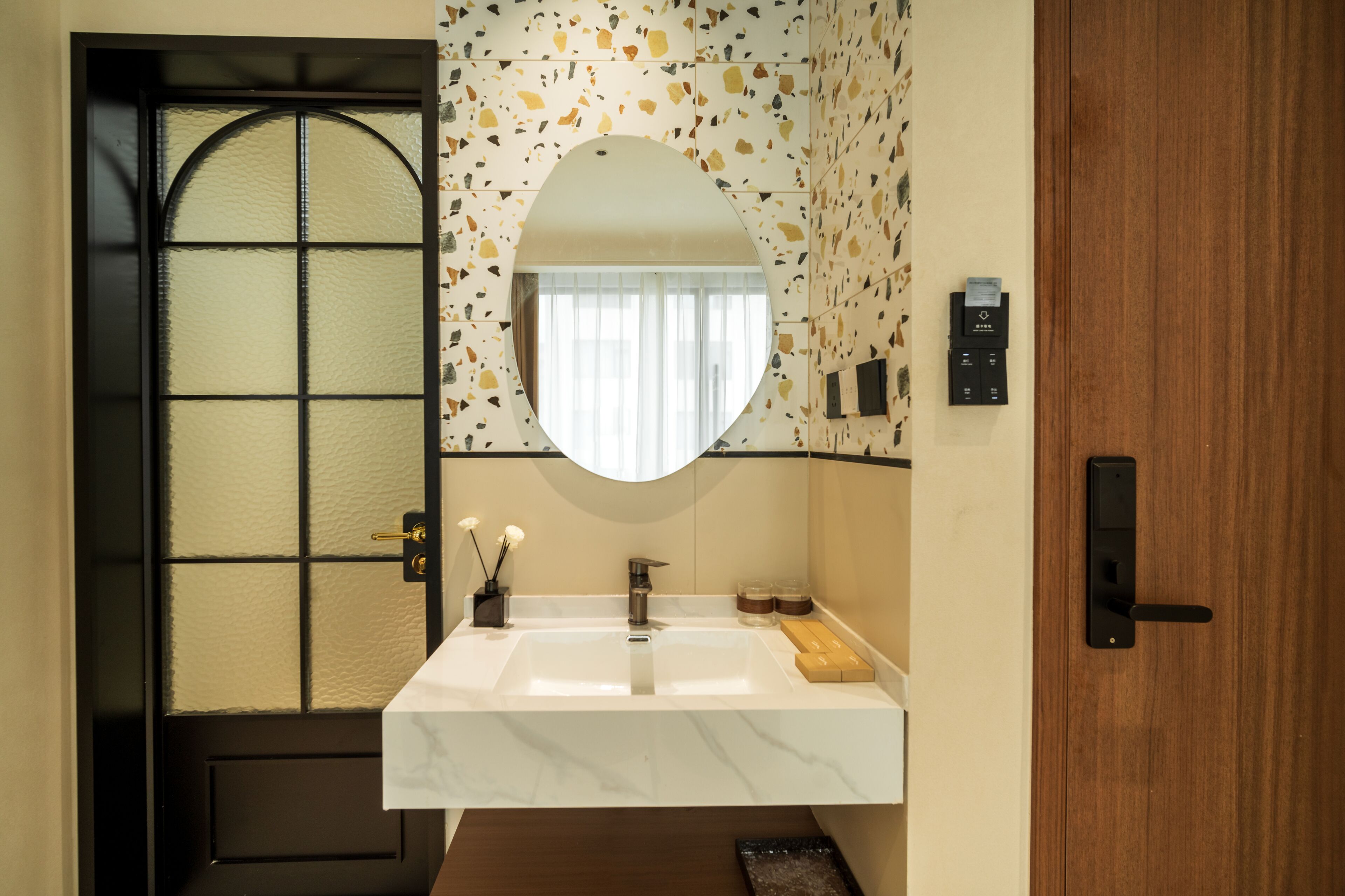 A bathroom with a white sink, a mirror, and a wooden door.