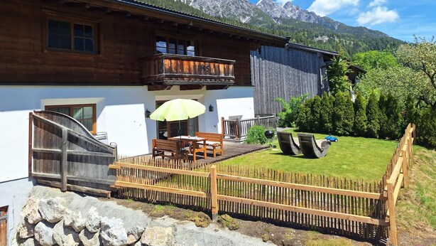 A chalet with a balcony, a wooden fence, and a mountain backdrop. - Holiday Home in Salzburg with Alpine View (Leogang)