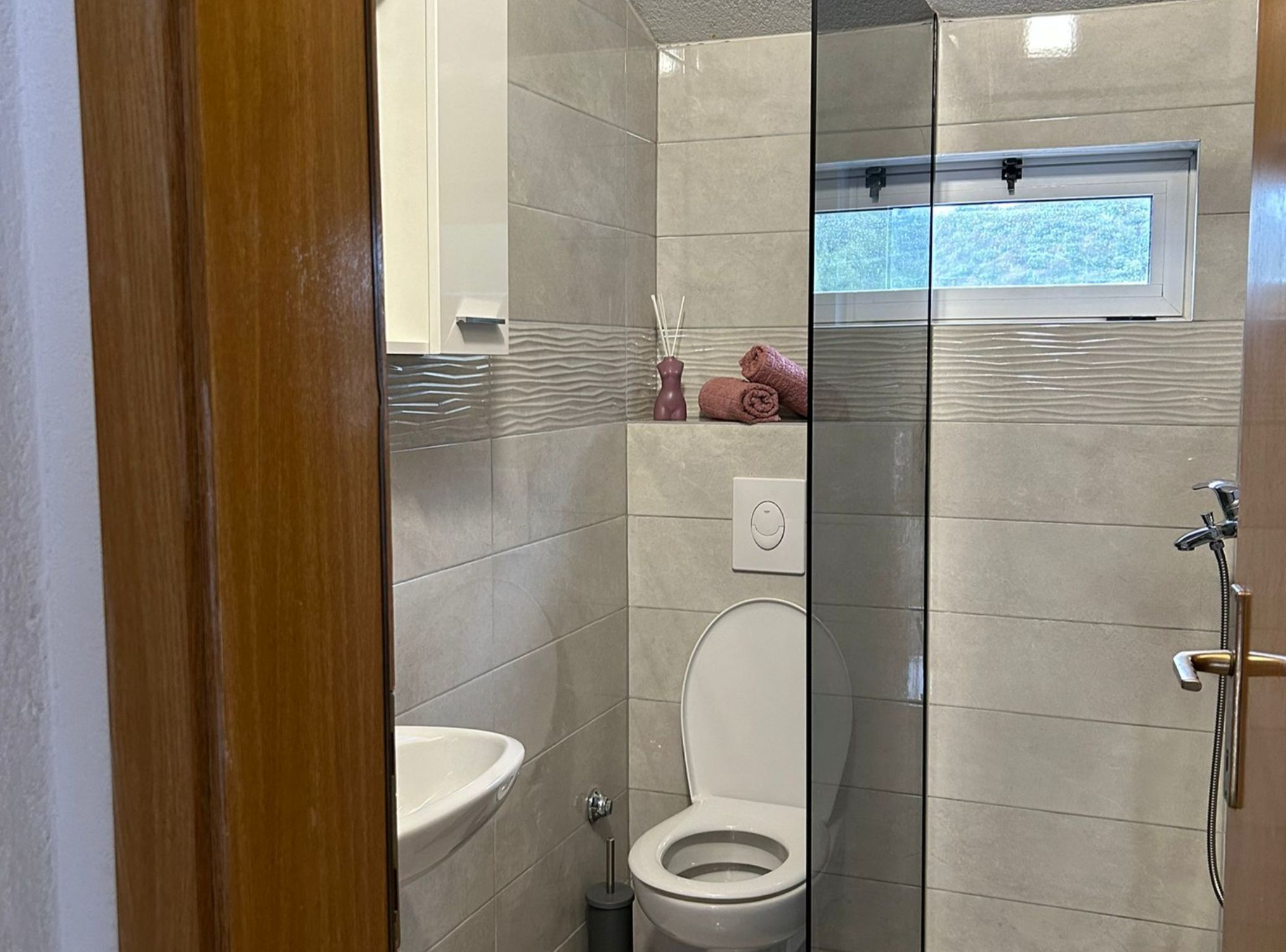 Un baño moderno con inodoro, lavamanos y ducha.