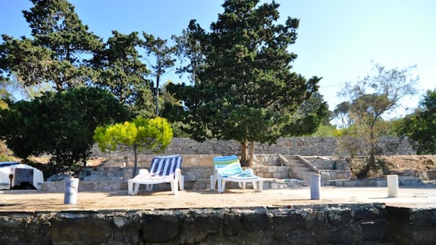 A stone wall with a clear view of the water below. - Apartman Olive Garden (Solta)