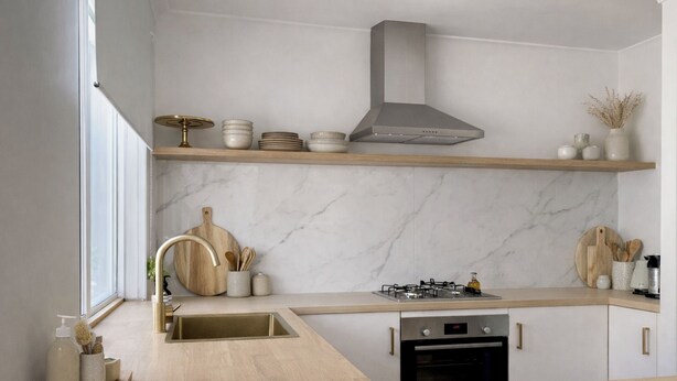 A modern kitchen with a wooden countertop, a stainless steel range hood, and a built-in dishwasher.